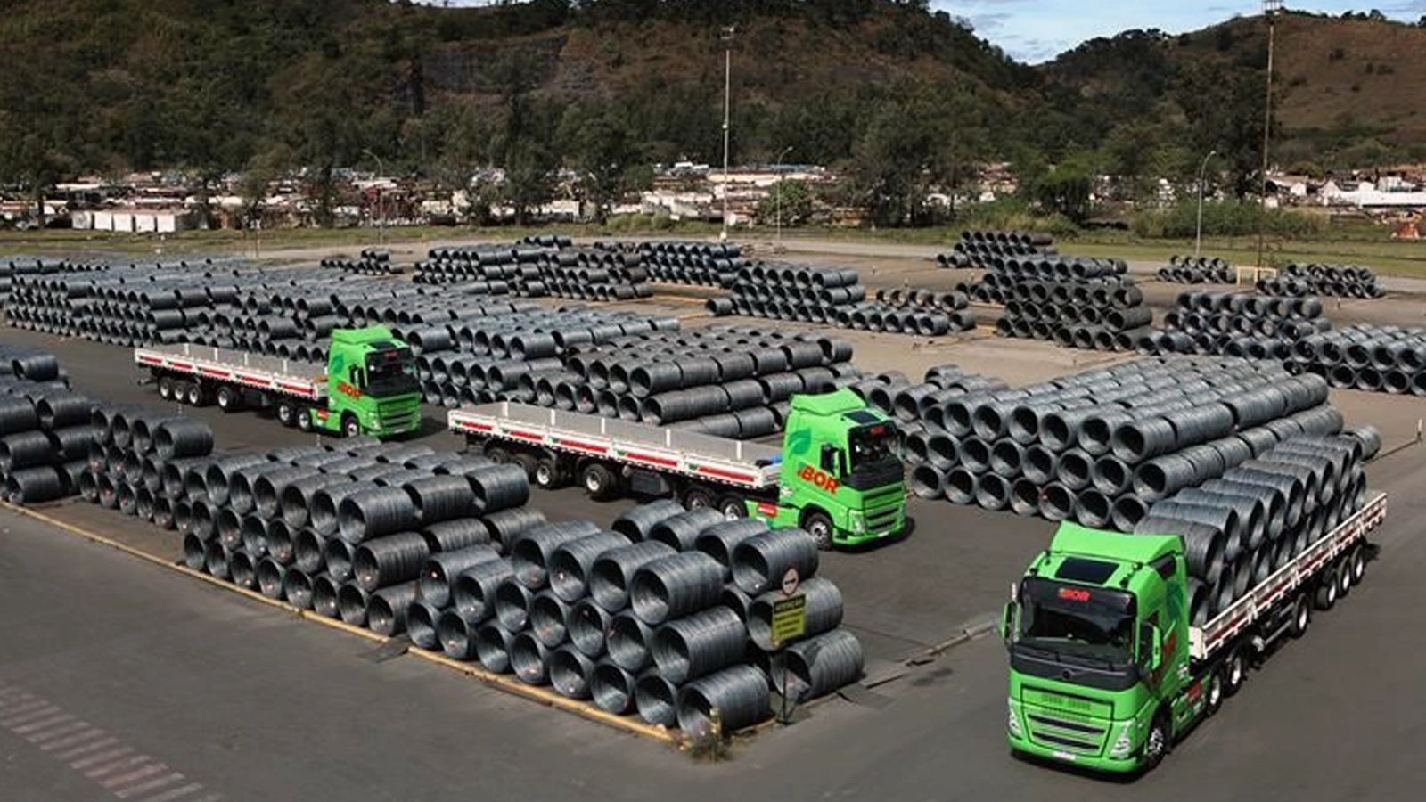 Caminhões da Frota Verde IBOR no pátio da ArcelorMittal carregando bobinas de fio-máquina.
